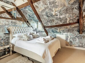 A bedroom with a large bed, a nightstand, and a mirror. - 5 bedroom accommodation in Croxton Kerrial, near Grantham (Croxton Kerrial, near Grantham)