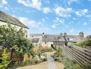 Un quartier résidentiel avec des maisons, une clôture en bois et un chemin de gravier.