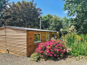 A wooden cabin with a sloped roof, a window, and a small porch area. - Rowan Tree Lodge - UKC6977 (Ludlow)