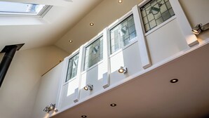 A room with skylights, a fireplace, and a window with a decorative glass panel.