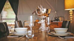 A dining table set with plates, glasses, and a silver trophy with a deer head. - The Star Dome - UKC6978 (Ludlow)