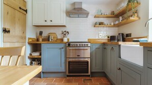 Una cocina compacta con estufa, horno y alacenas de madera.