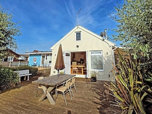 A single-story house with a patio, a table, and chairs. - Dinky Daze - UKC7071 (Brundall)