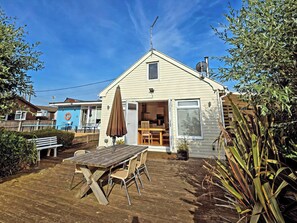 A single-story house with a patio, a table, and chairs. - Dinky Daze - UKC7071 (Brundall)