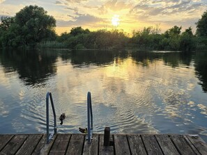 A wooden dock extending into a calm lake with a sunset in the background. - Dinky Daze - UKC7071 (Brundall)