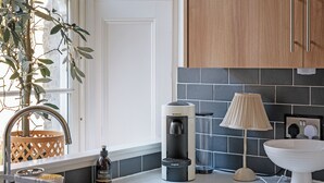 A modern kitchen with a coffee maker, a bottle of whiskey, a lamp, and a sink. - 2 bedroom accommodation in Birnam (Birnam)