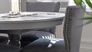 A round dining table with a glass candle holder, a plate, and a napkin. - 2 bedroom accommodation in Birnam (Birnam)