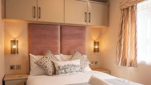 A hotel room with a bed, two bedside tables, a wardrobe, and decorative wall sconces. - 18 Ocean Terrace - UKC7117 (Ilfracombe)