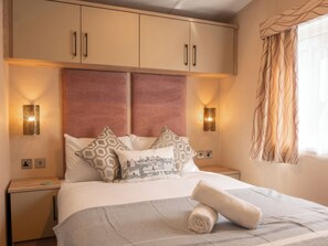 Ein Hotelzimmer mit einem Bett, zwei Nachttischen, einem Kleiderschrank und dekorativen Wandleuchten.