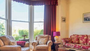 Ein Wohnzimmer mit Ledersofas, einem Holztisch und einer Lampe.
