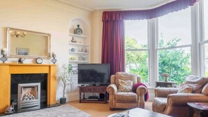 Ein Wohnzimmer mit Kamin, Fernseher und zwei Sofas.
