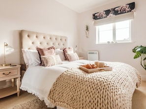 A bedroom with a tufted headboard, a bedside table with a lamp, a tray with croissants, and a large window with a view. - 2 bedroom accommodation in Warwick (Warwick)