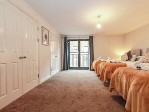 A hotel room with two beds, a large white wardrobe, and a balcony with a view. - Renta Apartments 4 - 44 - UK41136 (Southampton)