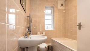 Ein modernes Badezimmer mit Waschbecken, Toilette und Badewanne.