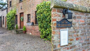 A brick building with a sign reading "The Carriage House".