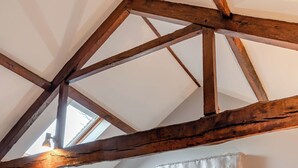 Een kamer met zichtbare houten balken en een dakraam.