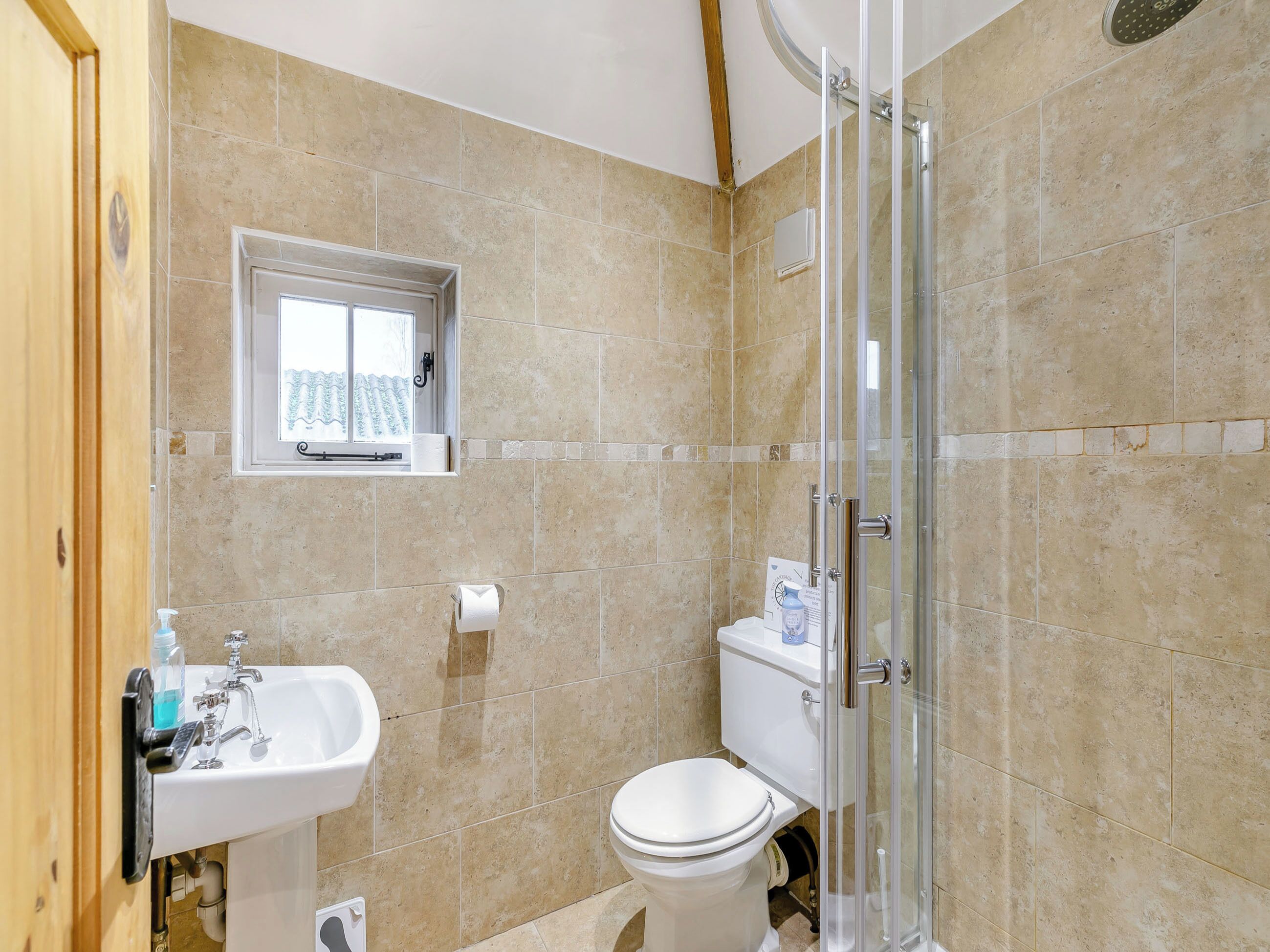 A bathroom with a toilet, sink, and shower.
