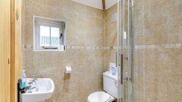 A bathroom with a toilet, sink, and shower.