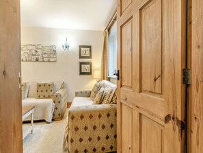 A cozy room with two patterned sofas, a wooden wardrobe, and a wall-mounted artwork. - Piper Cottage - UK41164 (Bilbrough, near York)