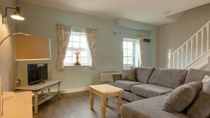 A living room with a sofa, a small table, a TV, and a lamp. - Peveril Cottage - E4642 (Darwin Lake, near Matlock)