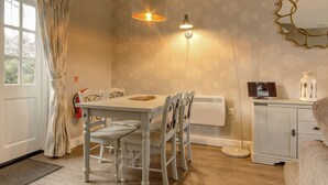 A dining area with a table, chairs, a pendant light, a radiator, and a cabinet. - Peveril Cottage - E4642 (Darwin Lake, near Matlock)