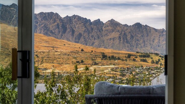 Uitzicht op een bergachtig landschap, met een stad op de voorgrond.