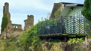 Uma construção de pedra histórica com ruínas e um edifício moderno com telhado verde.