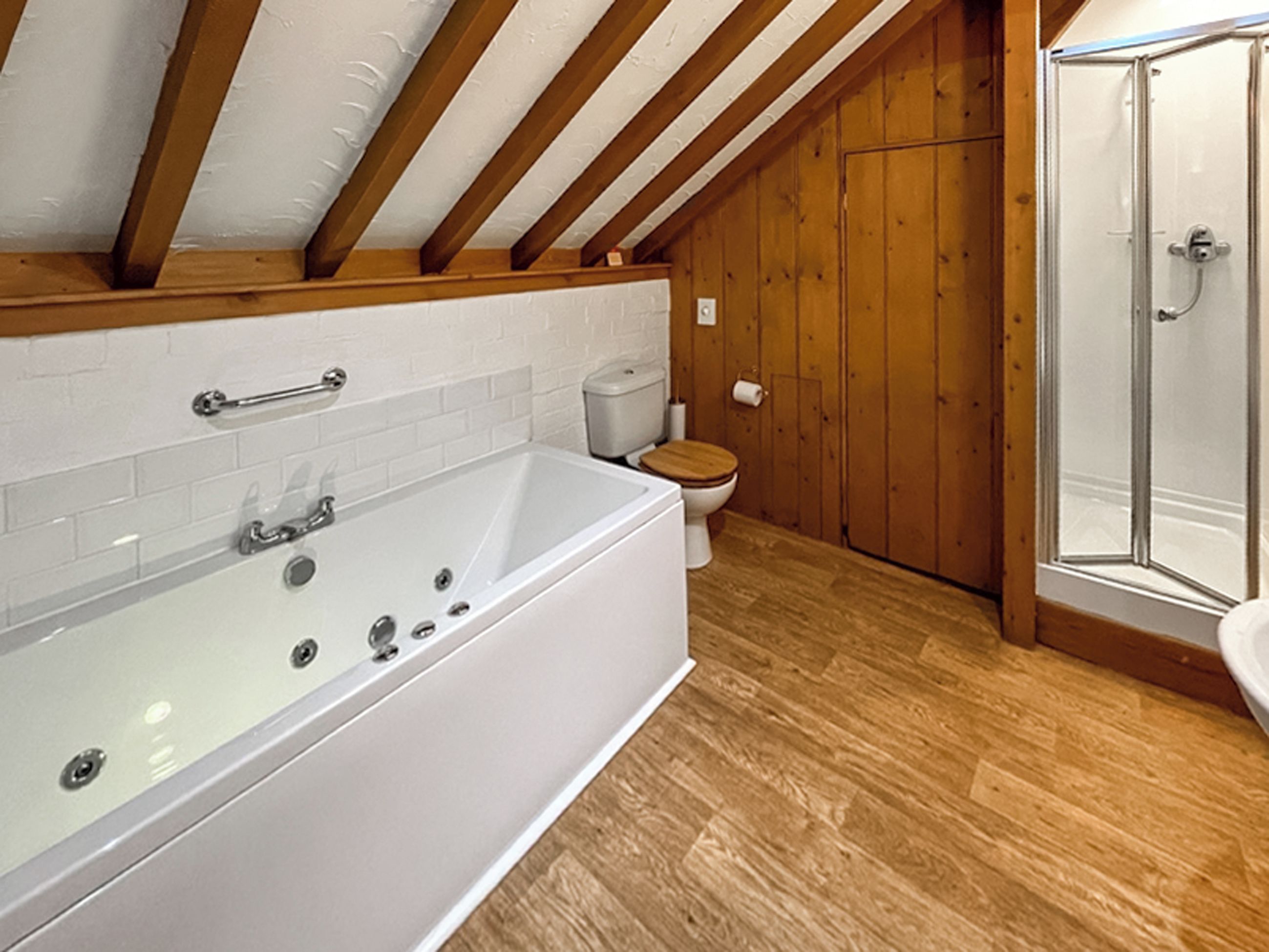 A bathroom with a bathtub, toilet, and shower.