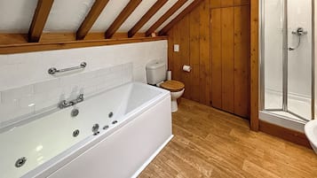 A bathroom with a bathtub, toilet, and shower.