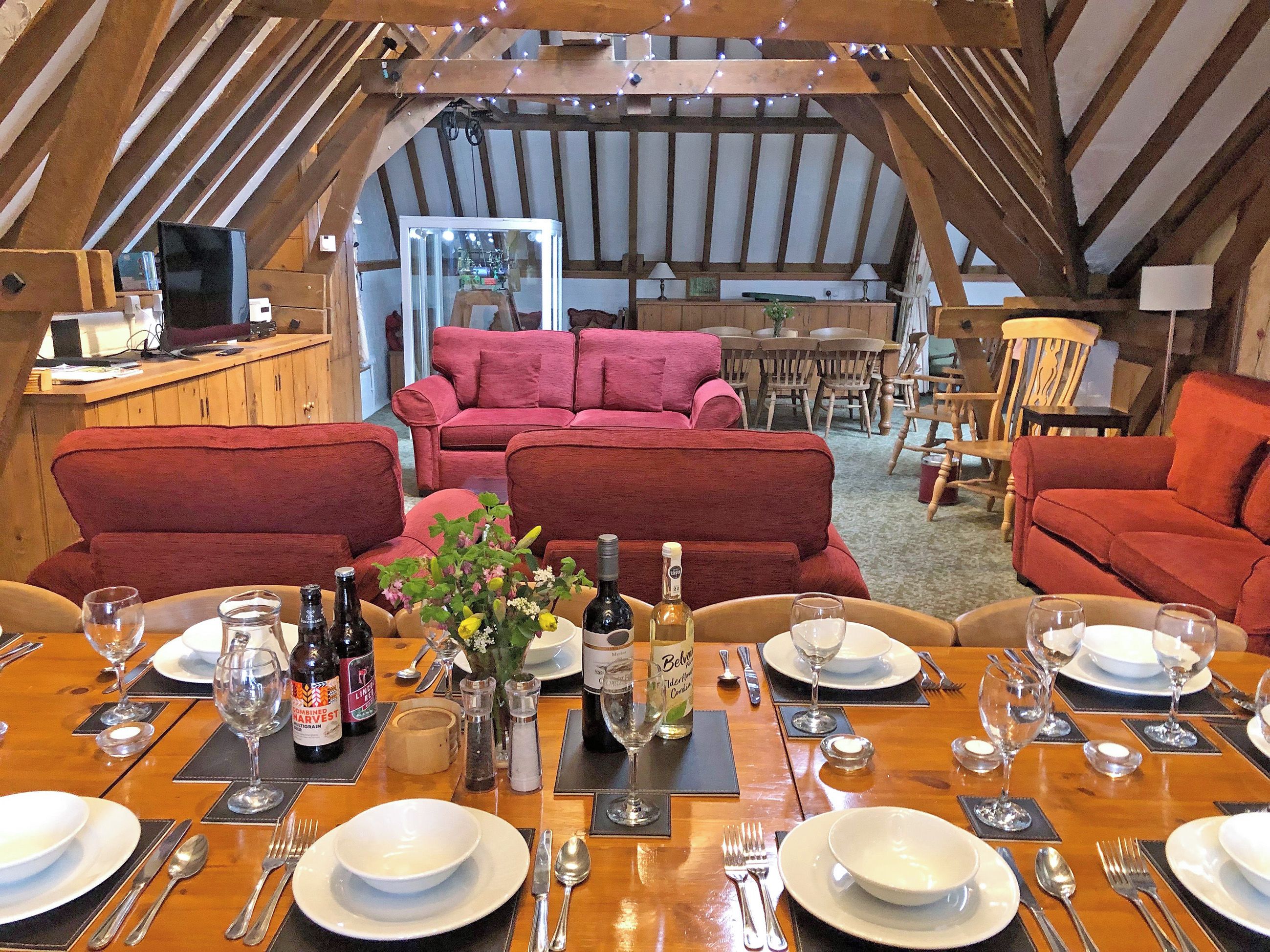A dining area with a wooden table set for a meal, surrounded by red upholstered chairs.