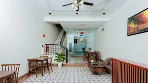 A spacious living area with a patterned floor, a staircase, and a dining area with wooden furniture. - Peaceful House located at central, 3 minutes walk to The old town & night market (Thành phố Hội An)