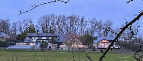 A residential area with multiple houses, a fenced yard, and leafless trees.
