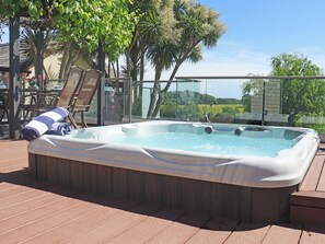 A hot tub on a wooden deck with chairs and a glass railing. - Deerview Lodge - UK51044 (Bonvilston)