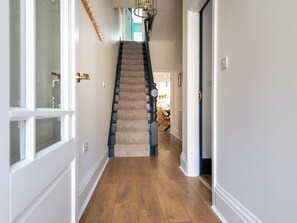 A staircase with a wooden finish, leading to a dining area with chairs and a table. - 6 bedroom accommodation in Scarborough (Scarborough)