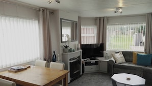 A compact living space with a dining table, sofa, and TV.