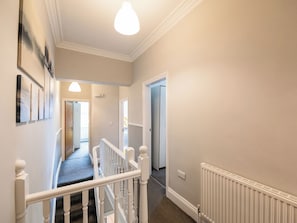 A hallway with a staircase, a radiator, and a door leading to another room. - Ashville Lodge - UK37119 (Scarborough)
