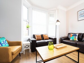 A modern living room with a brown leather sofa, a wooden coffee table, and a small white side table. - Ashville Lodge - UK37119 (Scarborough)