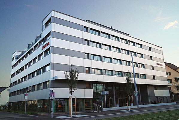 A modern hotel building with a flat facade, multiple windows, and a prominent 'HOTEL' sign. - H Hotel Zurich (Zürich)