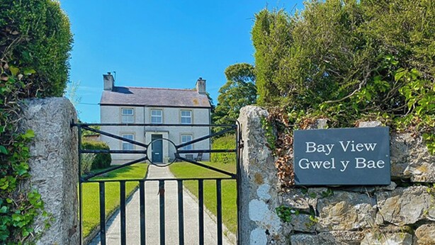 A gated entrance with a stone wall and a sign reading 'Bay View Gwel y Bae.' - 3 bedroom accommodation in Beaumaris (Beaumaris)