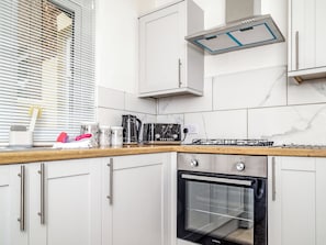 A modern kitchen with white cabinetry, a built-in oven, and a gas stove. - 3 bedroom accommodation in Barrow-in-Furness (Barrow-in-Furness)