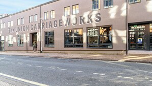 A building with the sign "The UNION CARRIAGE WORKS" on its facade.