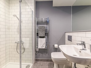 A modern bathroom with a glass-enclosed shower, a white sink, and a towel rack with towels. - Apartment 9 - UK42636 (Preston)
