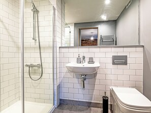A modern bathroom with a glass-enclosed shower, a white sink with two soap dispensers, and a toilet. - Apartment 16-UK42640 (Preston)