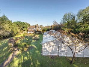 Une maison avec un grand jardin et une serre.