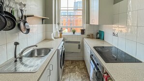 A modern kitchen with a built-in oven, a sink, and a stove. - 2 bedroom accommodation in Bristol (Bristol)