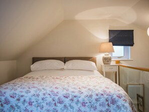 A bedroom with a bed, a nightstand, a lamp, and a window with a blind. - 1 bedroom accommodation in Biddenden, near Ashford (Biddenden, near Ashford)