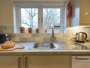 A kitchen with a stainless steel sink, a toaster, a bread loaf, a kettle, and a fire extinguisher. - 1 bedroom accommodation in Biddenden, near Ashford (Biddenden, near Ashford)