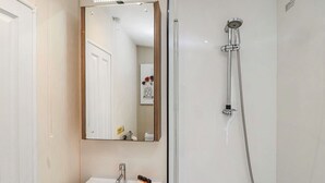 Ein Badezimmer mit Waschbecken, Spiegel und Dusche.