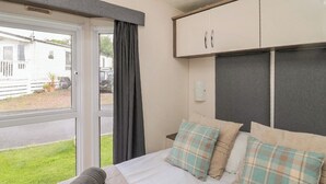 Ein Schlafzimmer mit Bett, Fenster und Kleiderschrank.