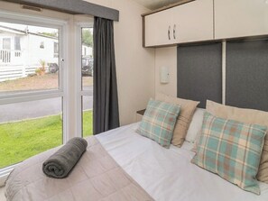 A bedroom with a bed, a window, and a wardrobe. - Mulberry Lodge - UK51192 (Morpeth)